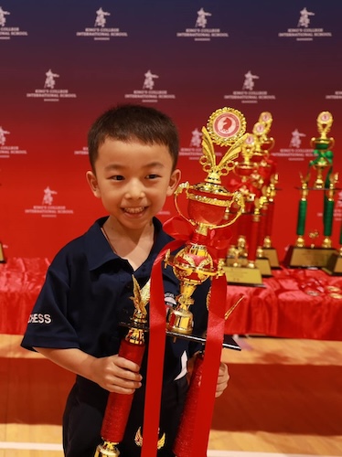 Young boy with big trophy at the King's Bangkok Chess Championship