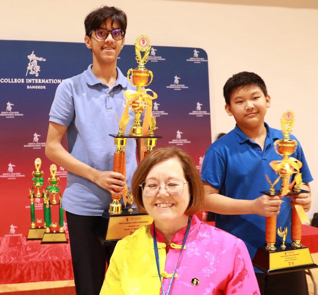 Two boys with chess trophies.