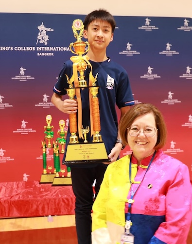 A boy with a large trophy at the King's Bangkok Chess Championship