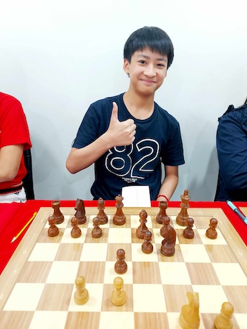 Boy enjoying Grandmaster Vladimir Lazarev at the Red Knight Chess Club for a simul event.