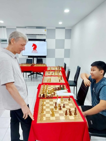 A boy with Grandmaster Vladimir Lazarev at Red Knight Chess Club for a simul event.