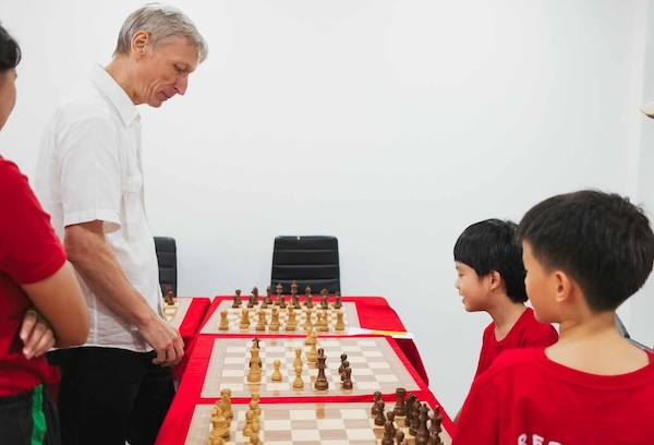 Grandmaster Vladimir Lazarev joins child chess players at Red Knight Chess Club for a simul event.