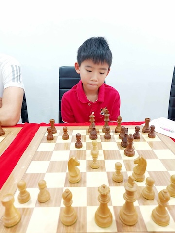 A boy contemplates his next chess move.