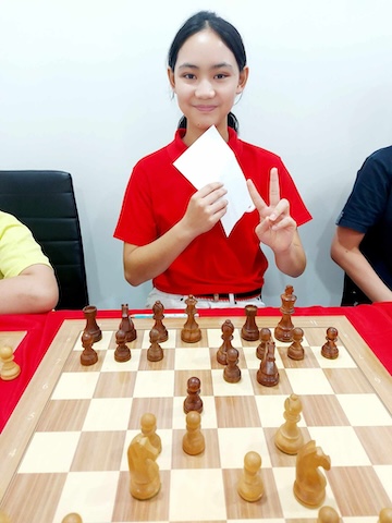 A young girl playing a simul event with Grandmaster Vladimir Lazarev.