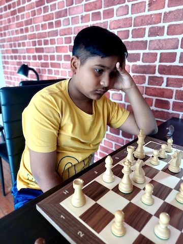 Boy playing chess at the Red Knight Chess Club in Bangkok.