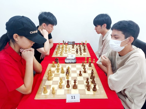 Kids playing chess at the Red Knight Chess Club in Bangkok.