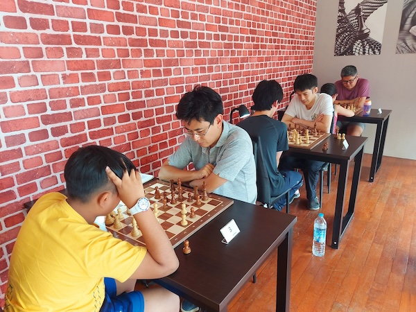 Kids on the chess team playing chess at the Red Knight Chess Club in Bangkok.