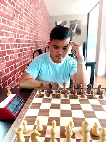 Man playing chess at the Red Knight Chess Club in Bangkok.